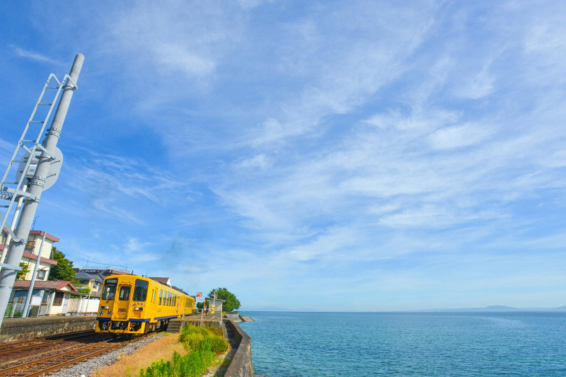 島原鐵道旁就是有明海上，黃色車身在藍天白雲陪襯下格外搶眼。    圖片提供：島原市